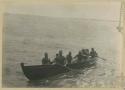 Men in canoe made of coconut wood in the form of a whaling boat