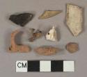 White kaolin pipe bowl fragments, 1 fragment burned, red brick fragments, dark olive green glass fragments, 1 heavily patinated, 1 slag fragment