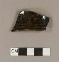 Undecorated lead glazed redware rim sherd; burned or overly fired