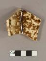 Cream-colored refined earthenware base, body, and rim sherd with brown tortiseshell decoration