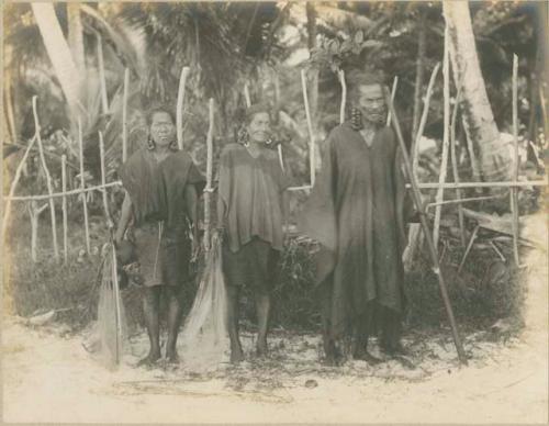 Two women with nets, and man with a pole