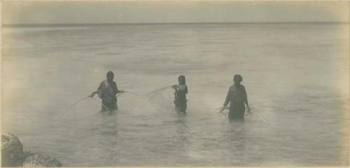 Three women fishing with nets