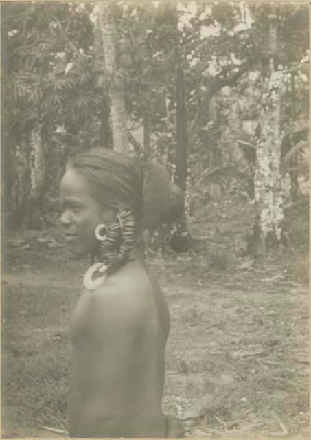 Man with large earring standing, side view