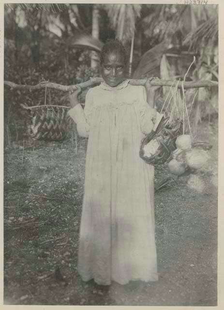 Woman carrying baskets on a tree limb