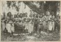 Group standing under a tree with clapsticks