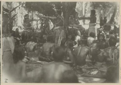 Dancers, with group sitting around them