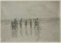 Group of men and children standing in shallow water