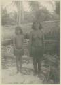 Woman and child standing in front of outrigger canoe