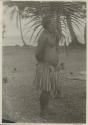 Man standing in front of palm, side view