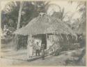 Woman and children in front of house