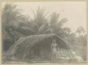 Man standing in front of hut