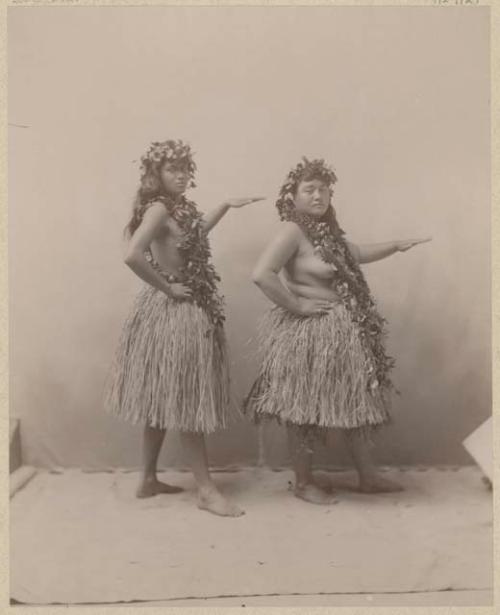 Two women in grass skirts and leis