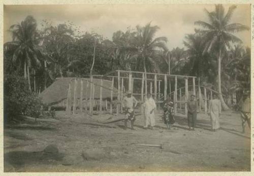 People standing in front of building frame under construction