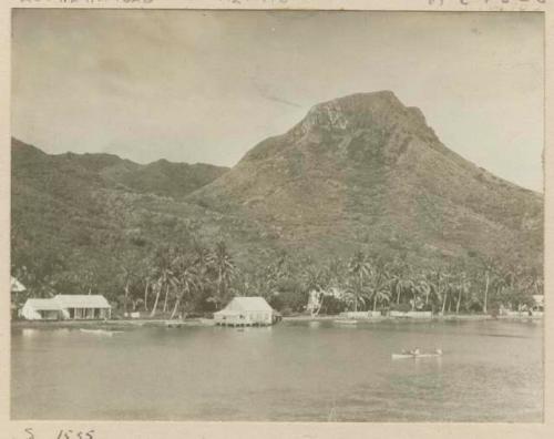 Shoreline with a view of houses, hills and boater in the foreground