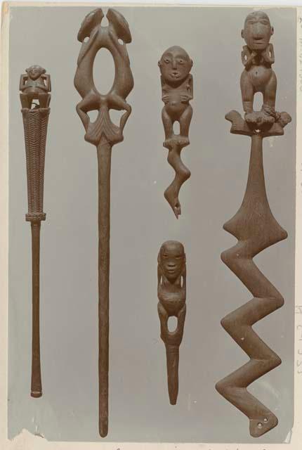 Five carved wooden anthropomorphic figurines and poles