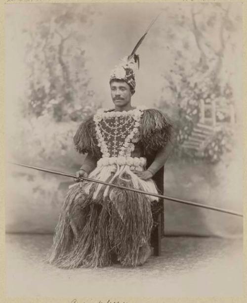 Studio portrait of man holding a long spear or pole