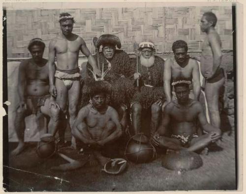 Group of tatooed men with objects some dressed in human hair clothing