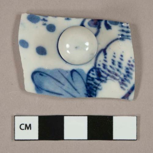 Blue on white hand painted porcelain lid fragment, knob intact, white paste