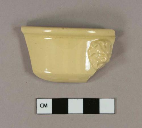 Yellow ware rim sherd with molded lion's head