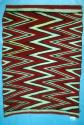Wedge weave rug with red, white and black zigzags