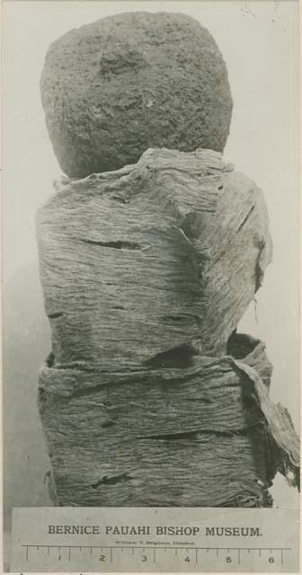 Stone anthropomorphic figure wrapped in fiber