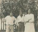 Two boys and a girl in front of fence