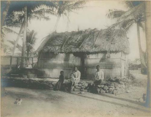 Men, children, and dogs in front of building