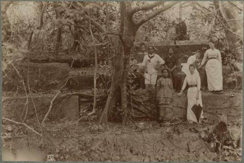 People, including women in Western dress, atop tomb