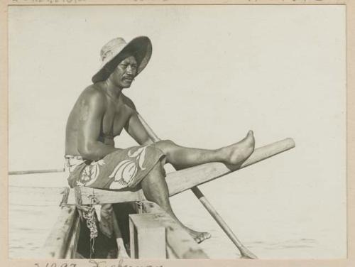 Fisherman sitting on prow of boat