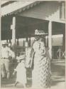 Man, woman, and child in front of structure