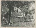 Man next to bamboo building under palm trees