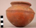 Red pottery bowl with incised lines around rim