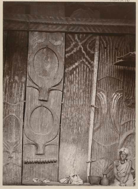 Woman sitting in front of carved wooden panels