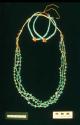 Three-strand necklace of turquoise on shell heishi, with a pair of jaklas