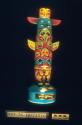 Ceramic totem pole whiskey bottle (A) with cap (B)