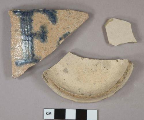 Tan salt-glazed stoneware vessel body and base fragments, largest body fragment with cobalt "F" on exterior