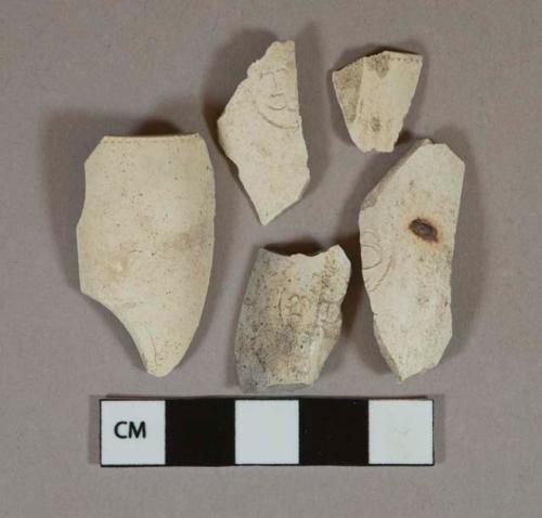 White Kaolin pipe bol fragments, 1 charred, 2 with rouletting around rim, 3 stamped "TD," "T[...]," or "[...]S"