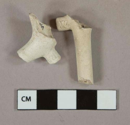 White kaolin pipe stem and bowl fragments, with "C" and "W" stamped on foot, 5/64 bore diameter.