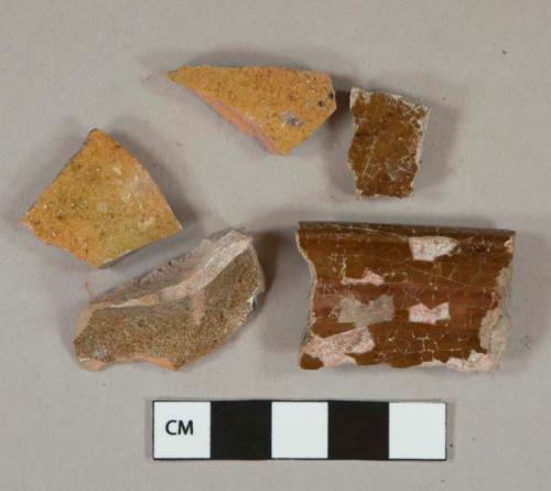 Red and yellow slip-glazed redware vessel body and rim fragments, red paste