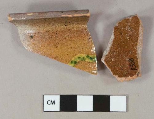 Brown, yellow, and green slip decorated redware vessel body and rim fragment, red paste