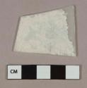 Colorless flat glass fragment, heavily patinated