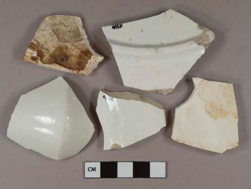 White undecorated ironstone vessel body, base, and rim fragments, white paste