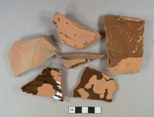 Brown lead glazed redware vessel base, body, and rim fragments, red paste