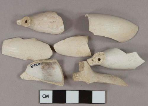 White kaolin pipe bowl fragments, 1 with rouletting around rim, 1 stamped with TD in cartouche, 1 with "G" on one side of foot and "W" on other side