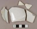 White undecorated pearlware vessel body, base, and rim fragments, white paste