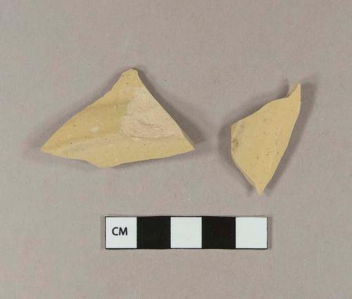 Unidentified refined earthenware or stoneware base sherds; buff paste, yellow glaze; two sherds crossmend