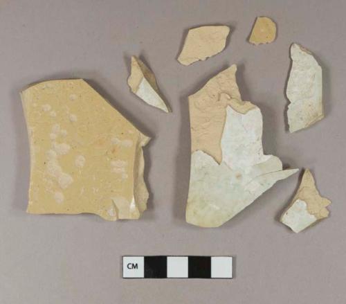 Unidentified refined earthenware or stoneware body sherds; buff paste, yellow glaze on one side, blue matte glaze on the other side; three sherds crossmend; two sherds crossmend