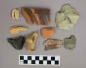Glass bottle fragments, flint nodules, stone flakes, ceramic body and base fragments, a tooth, and ferrous metal fragments