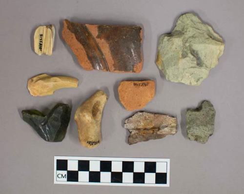 Glass bottle fragments, flint nodules, stone flakes, ceramic body and base fragments, a tooth, and ferrous metal fragments