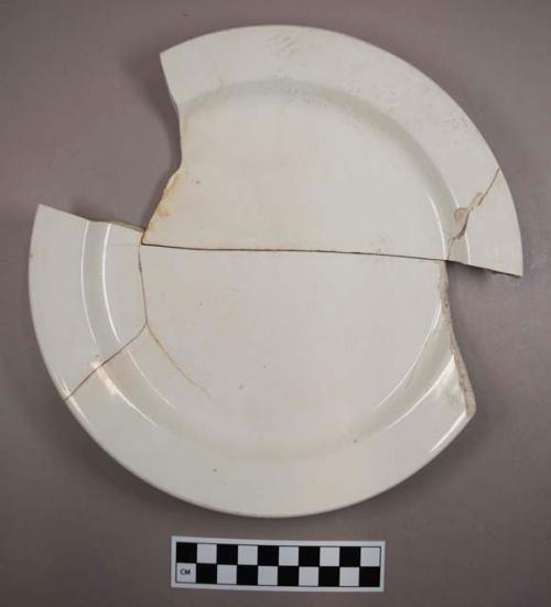 Plain white porcelain plate. partial. reconstructed from four sherds. 22.5x2.